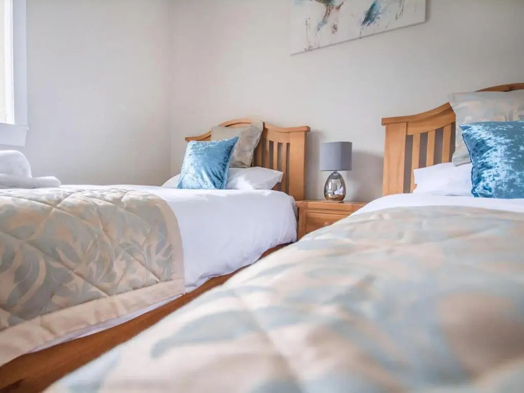 two beds sitting next to each other in a bedroom at 58 Moray Park in Culloden