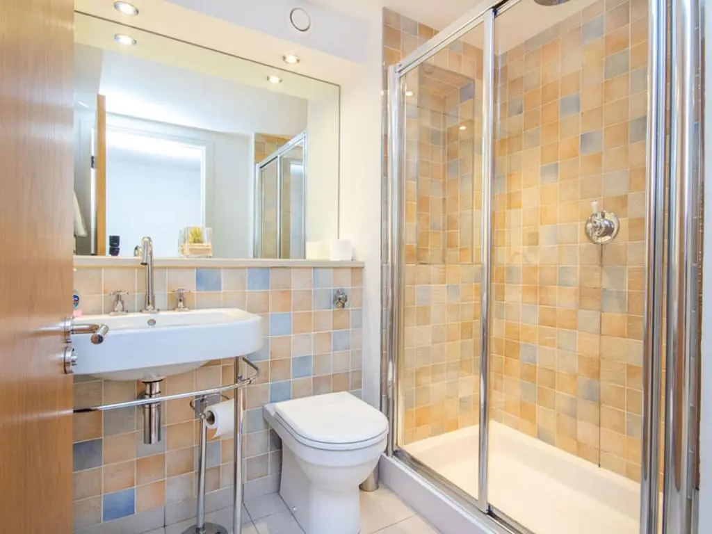 a bathroom with a toilet and a shower and a sink at 206 By The Bridge Apartment in Inverness