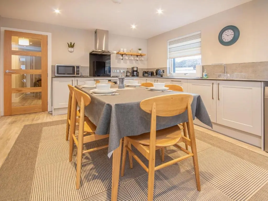 a kitchen with a table and chairs in a kitchen at Sunnyside Culloden in Inverness
