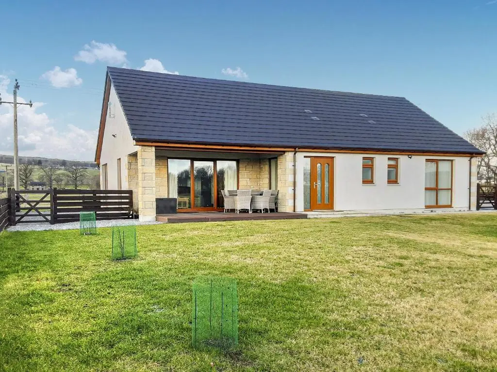 a small white house with a black roof at Terra Verde in Beauly