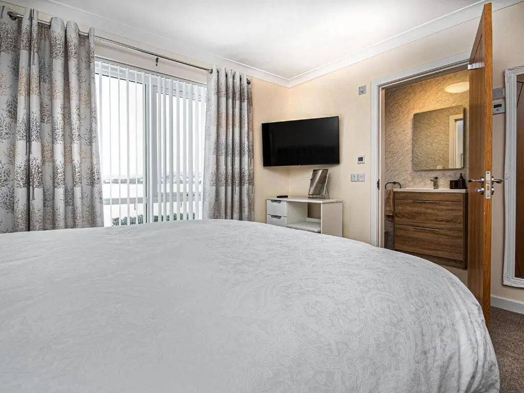 a bedroom with a large bed and a television at Terra Verde in Beauly