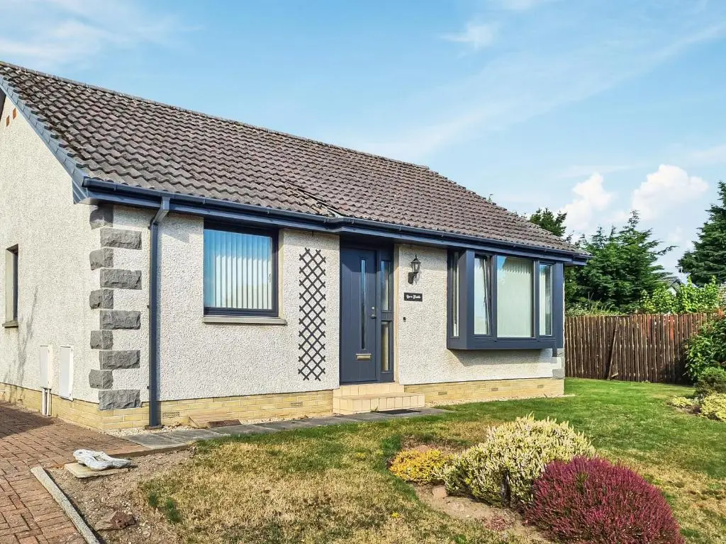 a house with a blue door and a yard at Bow Fiddle in Nairn