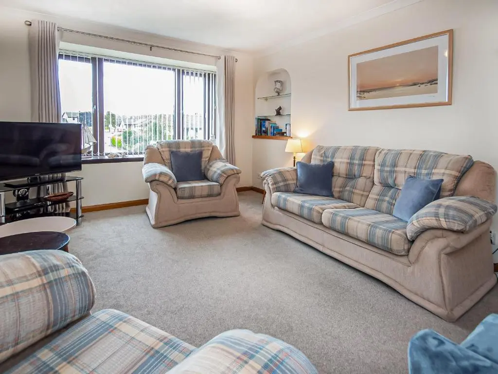 a living room with two couches and a television at Bow Fiddle in Nairn