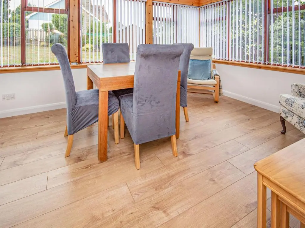 a dining room with a wooden table and chairs at Bow Fiddle in Nairn