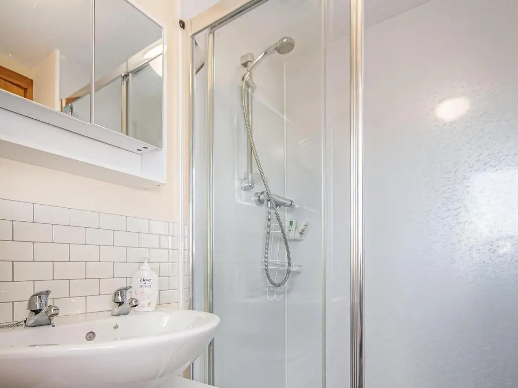 a bathroom with a shower and a sink at Sunnyside Cottage in Embo