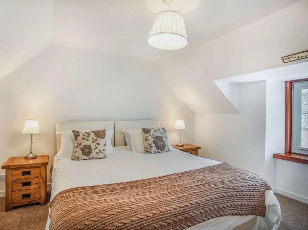 a bedroom with a large bed with two night stands at 4 Bed in Tomintoul 46162 in Tomintoul