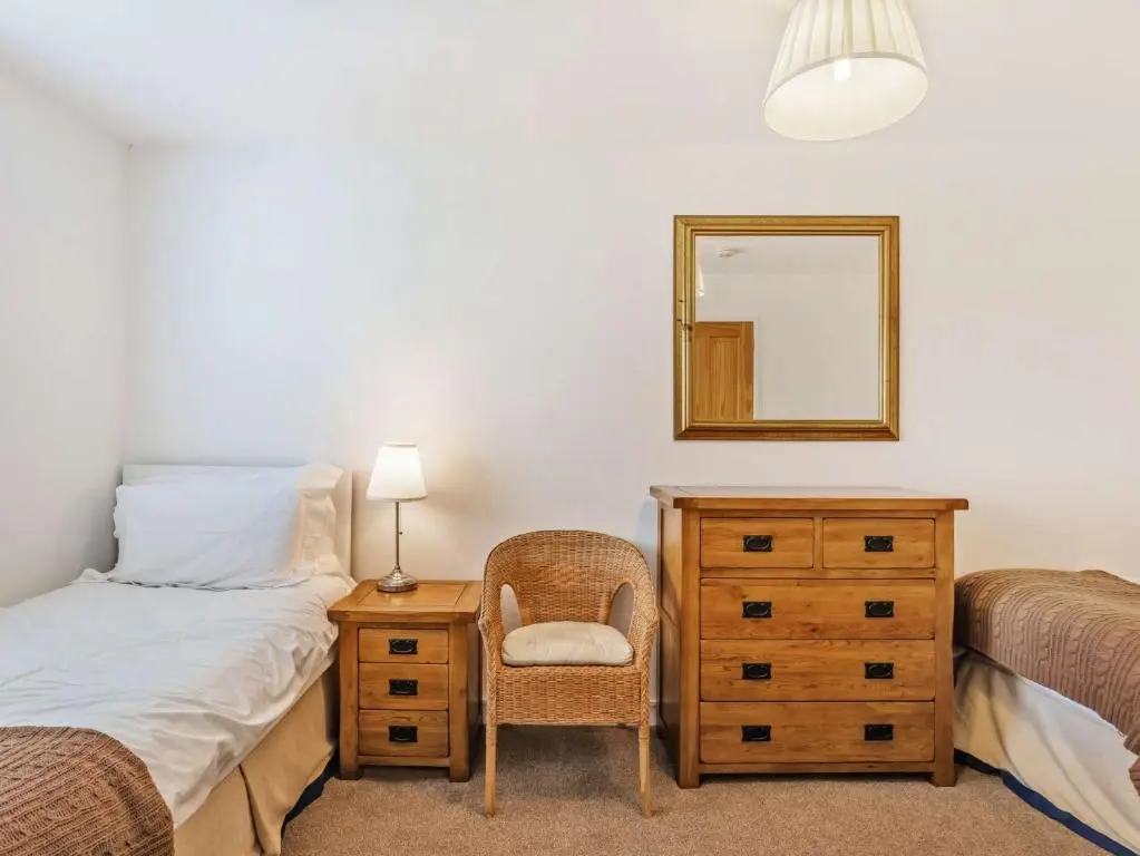 a bedroom with a bed and a dresser and a mirror at 4 Bed in Tomintoul 46162 in Tomintoul