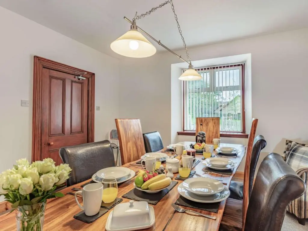 a dining room with a wooden table and chairs at 4 Bed in Tomintoul 46162 in Tomintoul