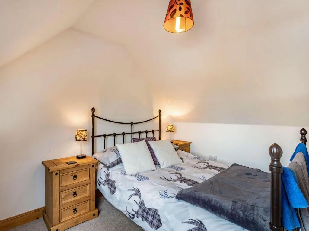 a bedroom with a bed and a wooden dresser at 3 Bed in Huntly 57368 in Insch