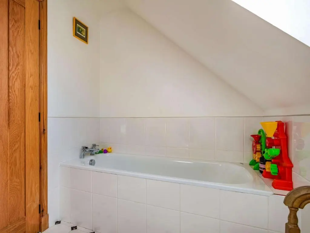 a bathroom with a white bath tub in a attic at 3 Bed in Huntly 57368 in Insch