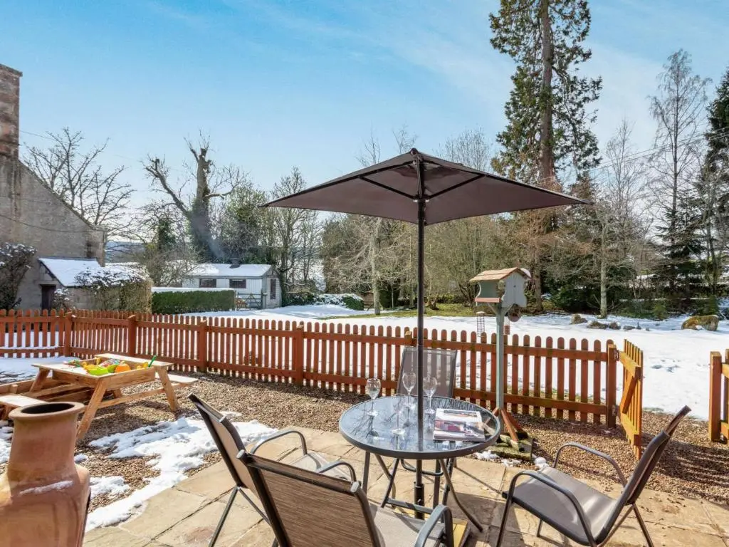 a table and chairs with an umbrella on a patio at 3 Bed in Huntly 57368 in Insch