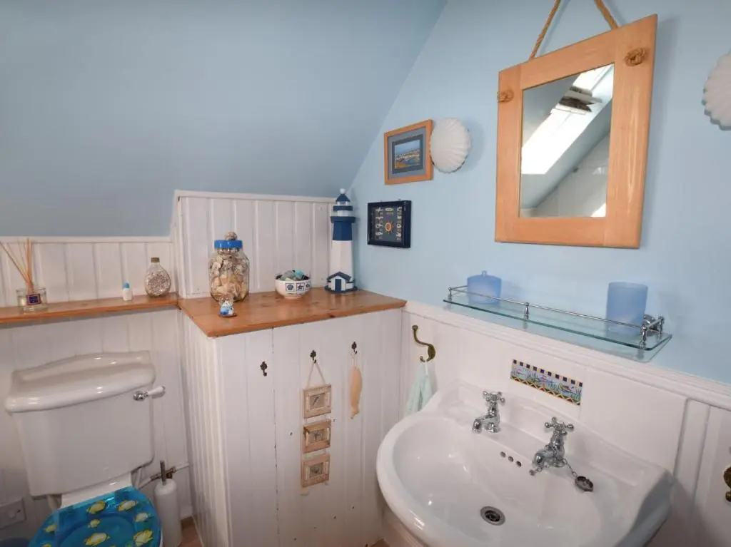 a bathroom with a sink and a toilet and a mirror at 2 Bed in Findochty 76557 in Findochty