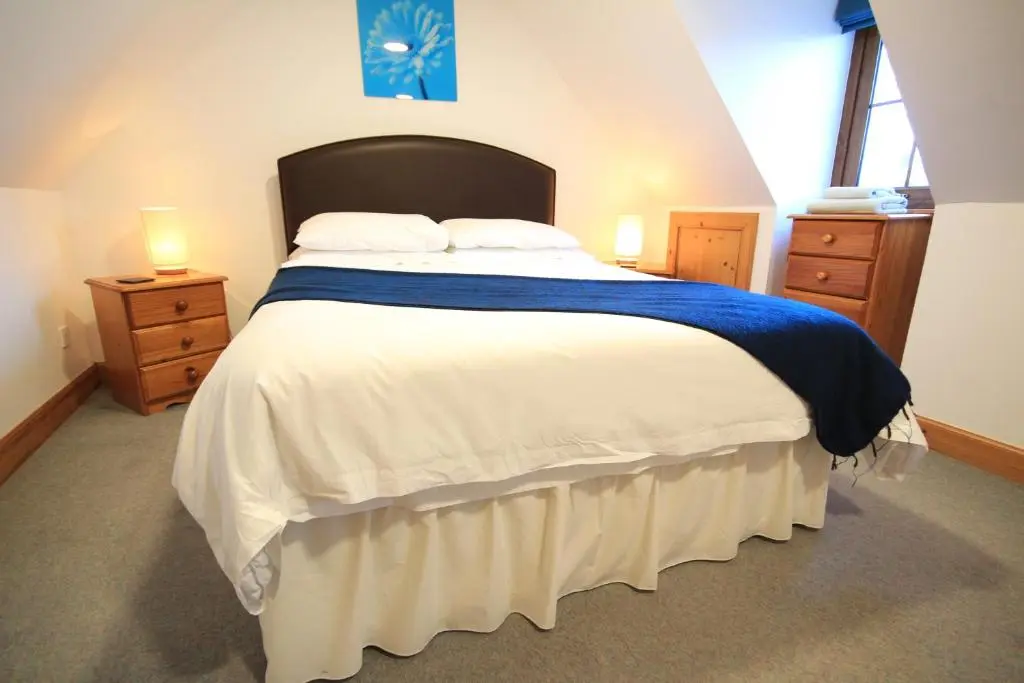 a bedroom with a large bed and two night stands at 23 Fairfield in Inverness