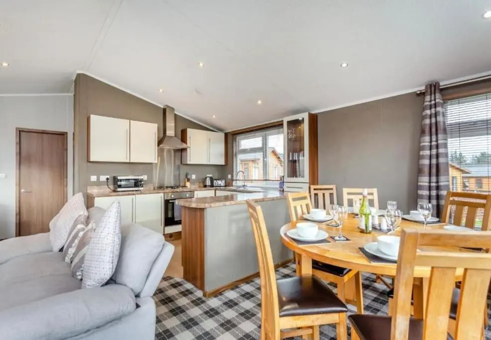 a living room with a table and a kitchen at Scottish retreat in Banchory