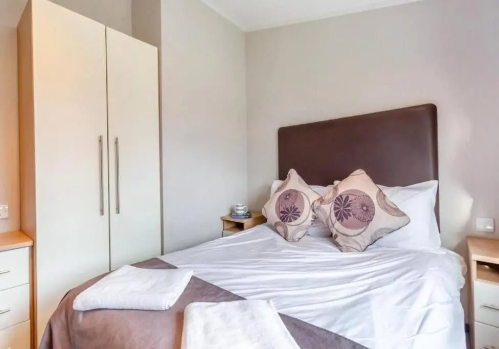 a bedroom with a bed with white sheets and pillows at Scottish retreat in Banchory