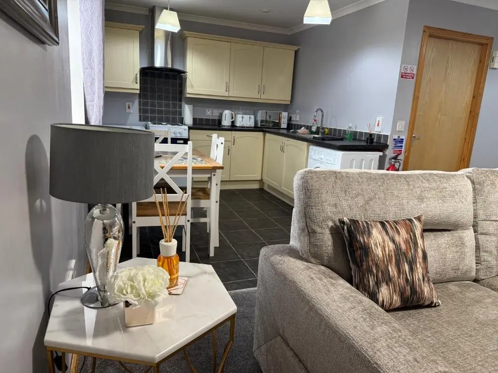 a living room with a couch and a table with a lamp at The Old Salt House, Flat 2 in Wick
