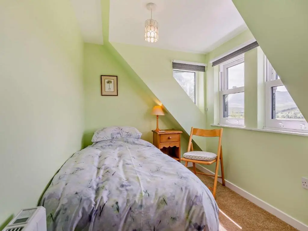 a bedroom with a bed with a purple comforter at 3 Bed in Kildonan SU192 in Helmsdale