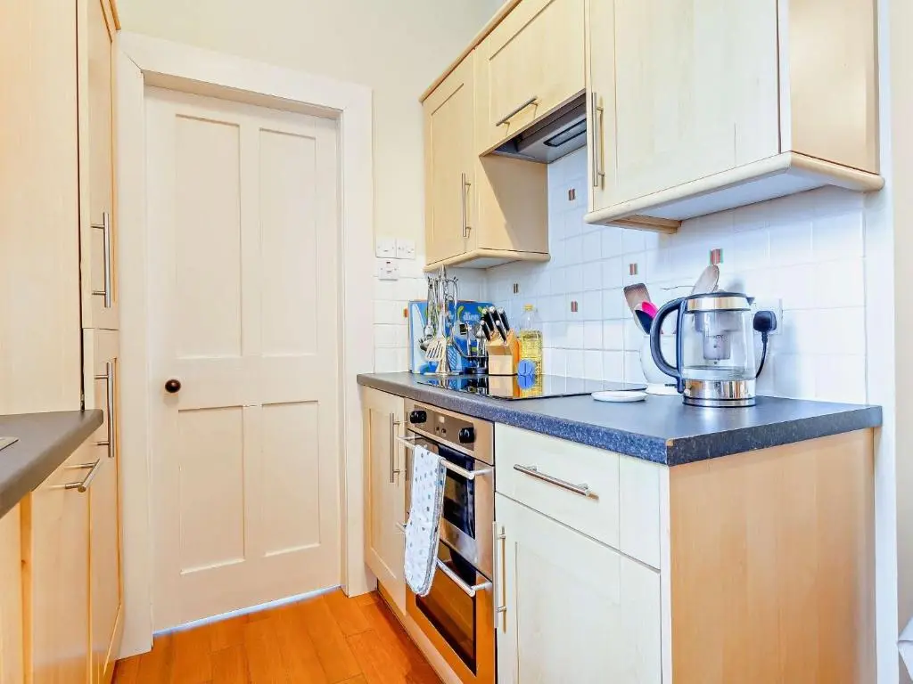 a kitchen with white cabinets and a blue counter top at 2 Bed in Conon Bridge CA387 in Cononbridge
