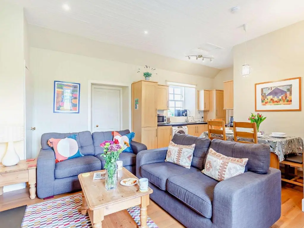 a living room with two blue couches and a table at 2 Bed in Conon Bridge CA387 in Cononbridge