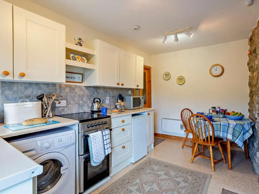 a kitchen with a washing machine and a table at 1 Bed in Beauly 82778 in Beauly
