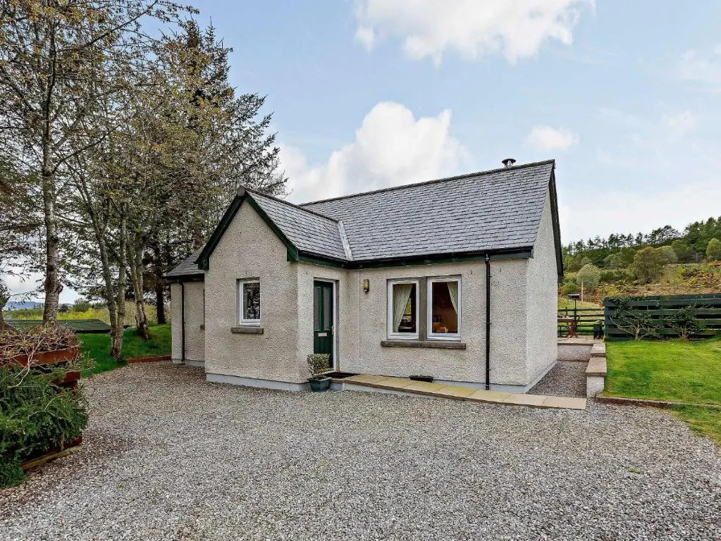 a small white house on a gravel driveway at 1 Bed in Beauly 82779 in Beauly