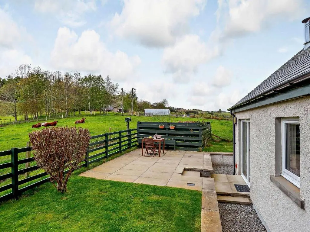 a patio with a table and a fence and a field at 1 Bed in Beauly 82779 in Beauly