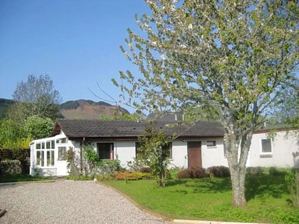 a white house with a tree in front of it at Balorrin in Contin