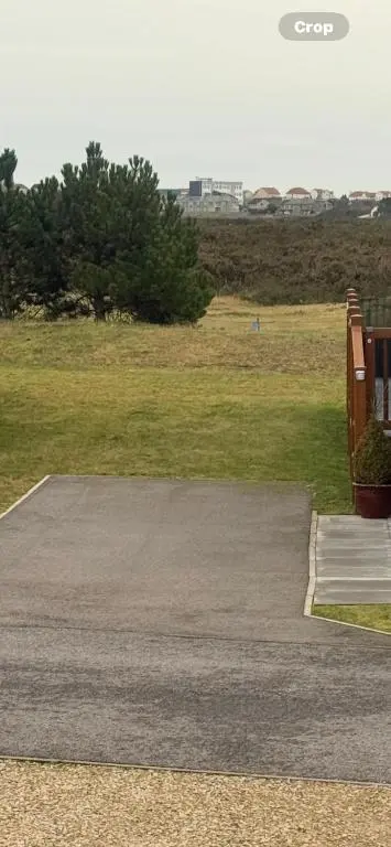 a parking lot with a field of green grass at Aurora luxury beach lodge in Lossiemouth