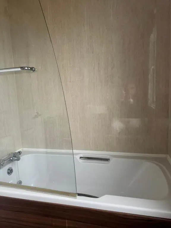 a white bath tub with a glass enclosure in a bathroom at Aurora luxury beach lodge in Lossiemouth