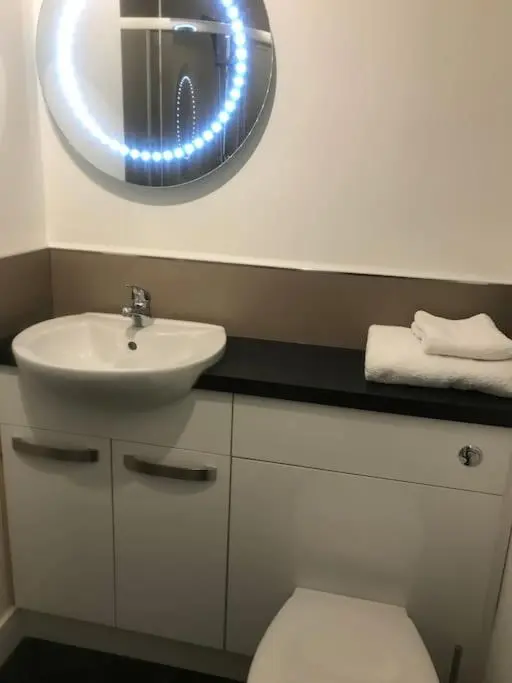 a bathroom with a sink and a toilet and a mirror at Elgin, home from home in Elgin