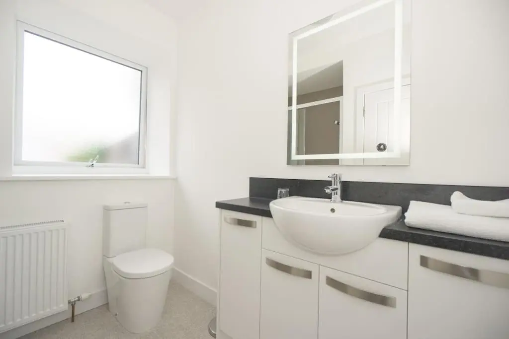 a white bathroom with a sink and a toilet at Elgin, home from home in Elgin