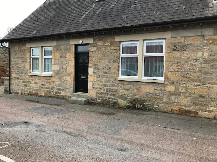 a brick house with a black door and windows at Elgin, home from home in Elgin