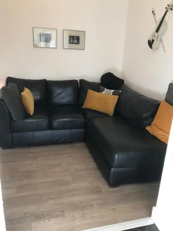 a black leather couch in a living room at Elgin, home from home in Elgin