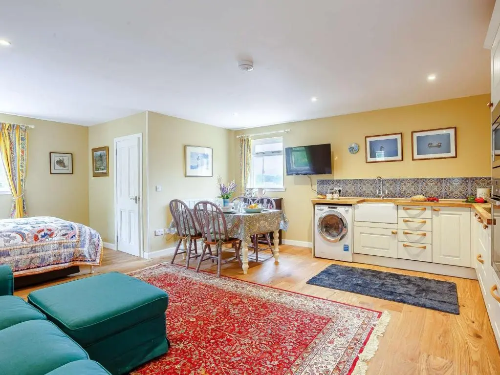 a living room with a blue couch and a table at 1 Bed in Balblair 89058 in Culrain