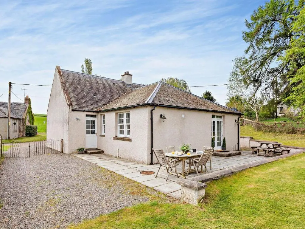 a white cottage with a patio and a table at 3 Bed in Conon Bridge CA388 in Cononbridge