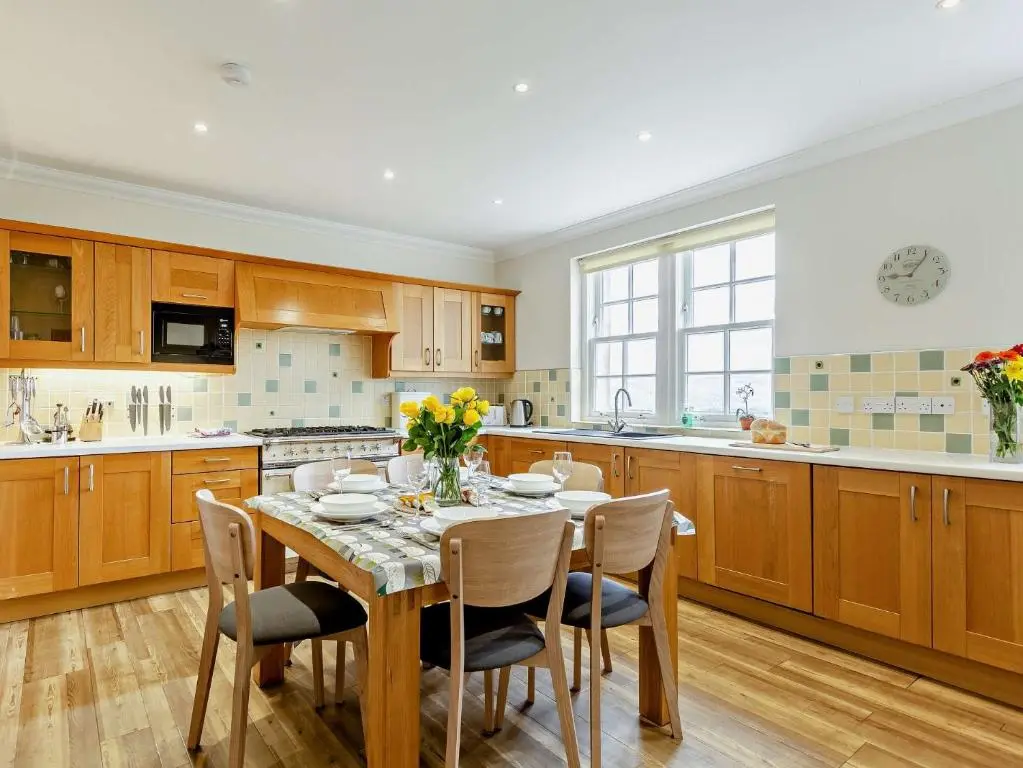 a kitchen with a wooden table and chairs and a table and chairsktop at 3 Bed in Conon Bridge CA388 in Cononbridge