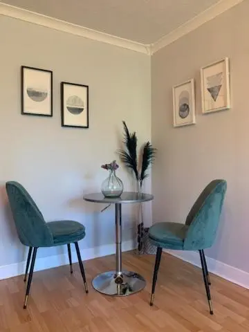 two green chairs and a table in a room at Modern One Bedroom Apartment in Lossiemouth
