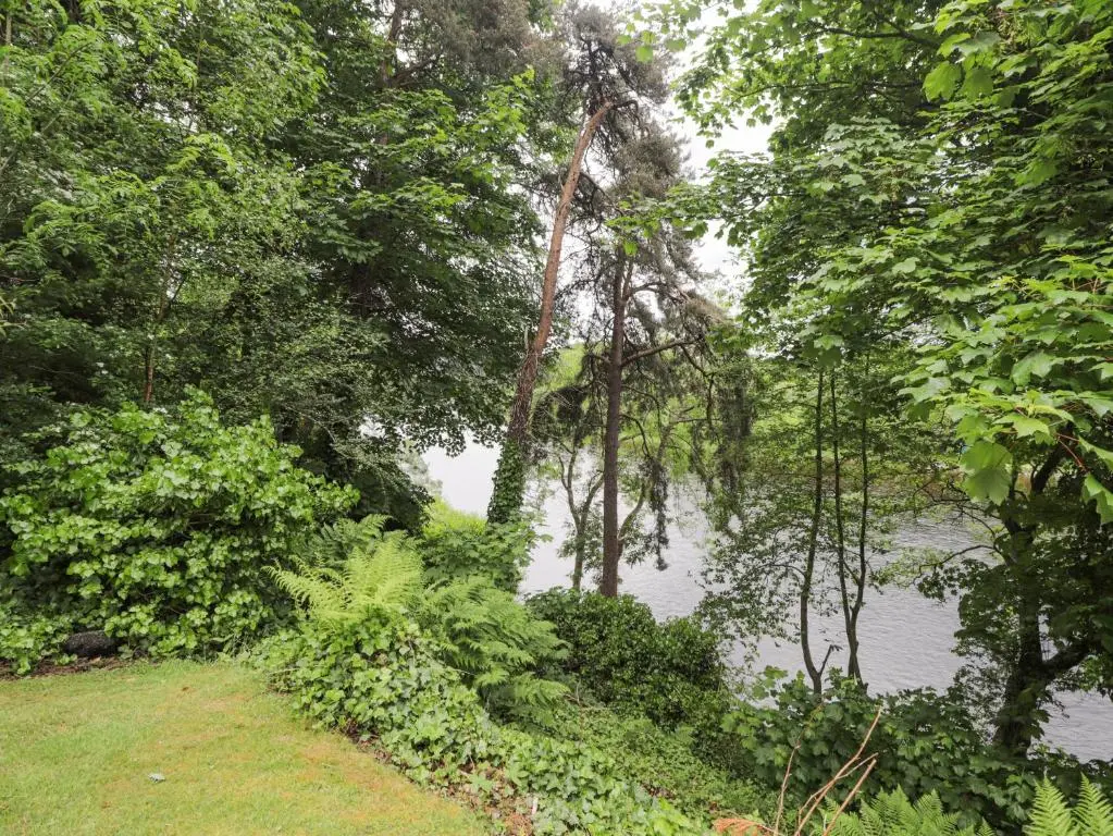 a body of water with trees and a river at Rossie Lodge in Inverness