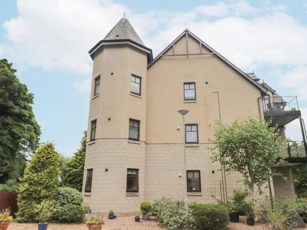 an old brick building with a tower at Rossie Lodge in Inverness