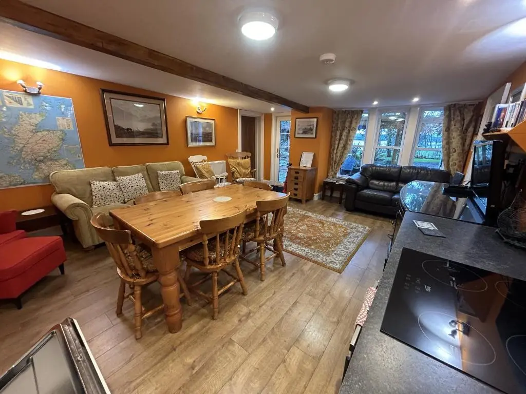 a living room with a wooden table and a couch at The Secret Garden at Old Drynie House - Self Catering in Inverness