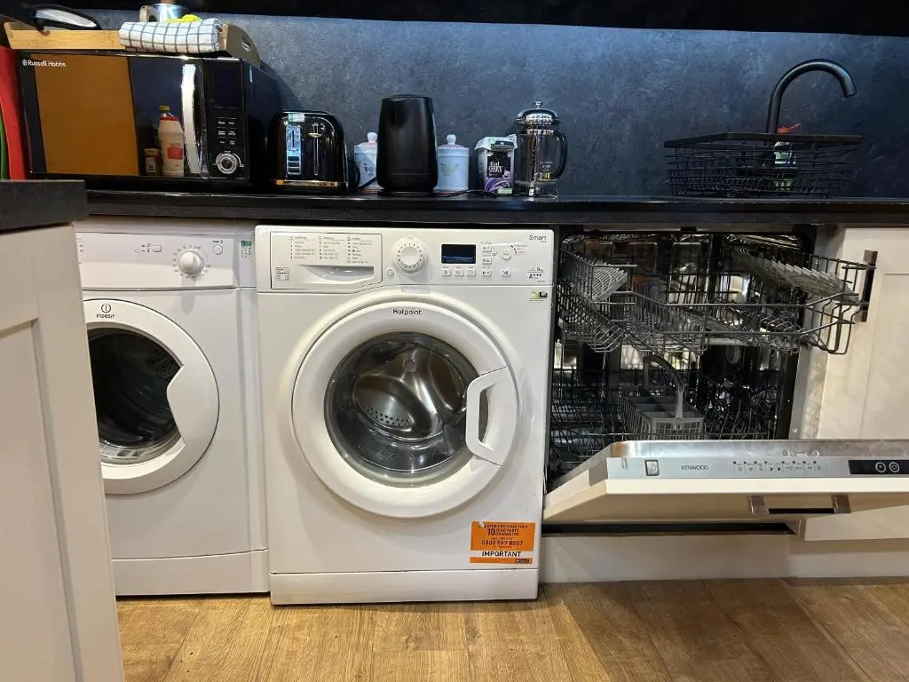 a kitchen with a washing machine and a washer at The Secret Garden at Old Drynie House - Self Catering in Inverness