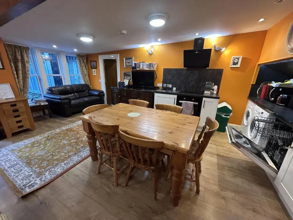 a kitchen and dining room with a wooden table and chairs at The Secret Garden at Old Drynie House - Self Catering in Inverness