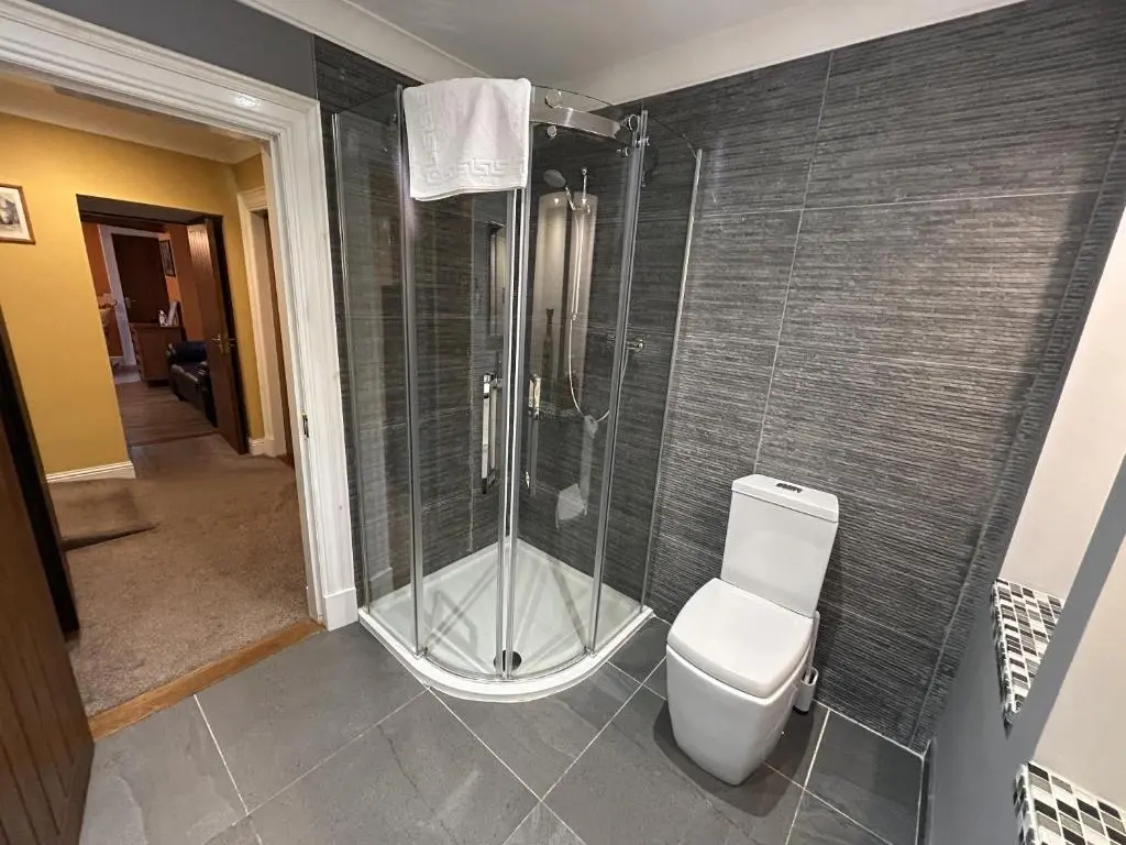 a bathroom with a shower and a toilet at The Secret Garden at Old Drynie House - Self Catering in Inverness
