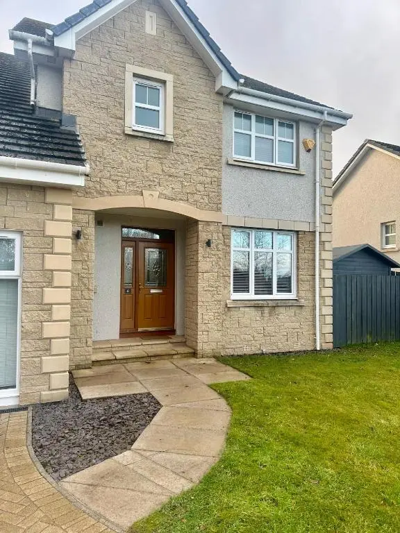 a brick house with a brown door and a yard at BraeView House in Inverness