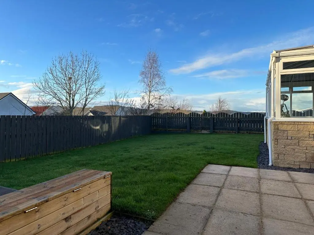 a backyard with a fence and a grass yard at BraeView House in Inverness