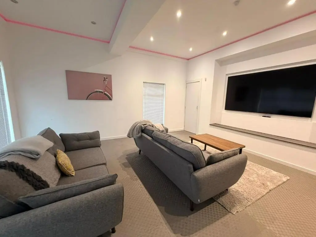 a living room with two couches and a flat screen tv at BraeView House in Inverness