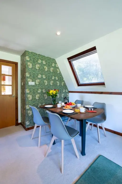 a dining room with a table and chairs at Chalet Caledonia Lodge by Interhome in Spean Bridge