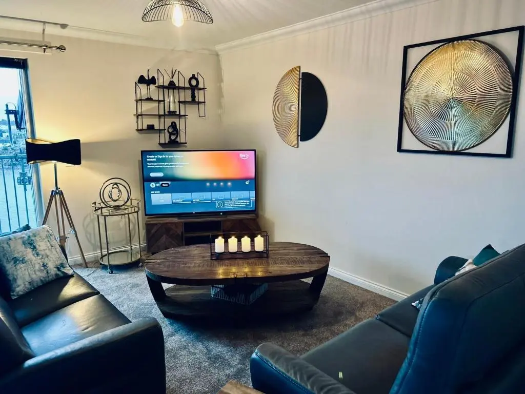 a living room with a coffee table and a television at Central Cosy Riverview Apartment 2 bed, 2 bath, Free Parking / WiFi in Inverness
