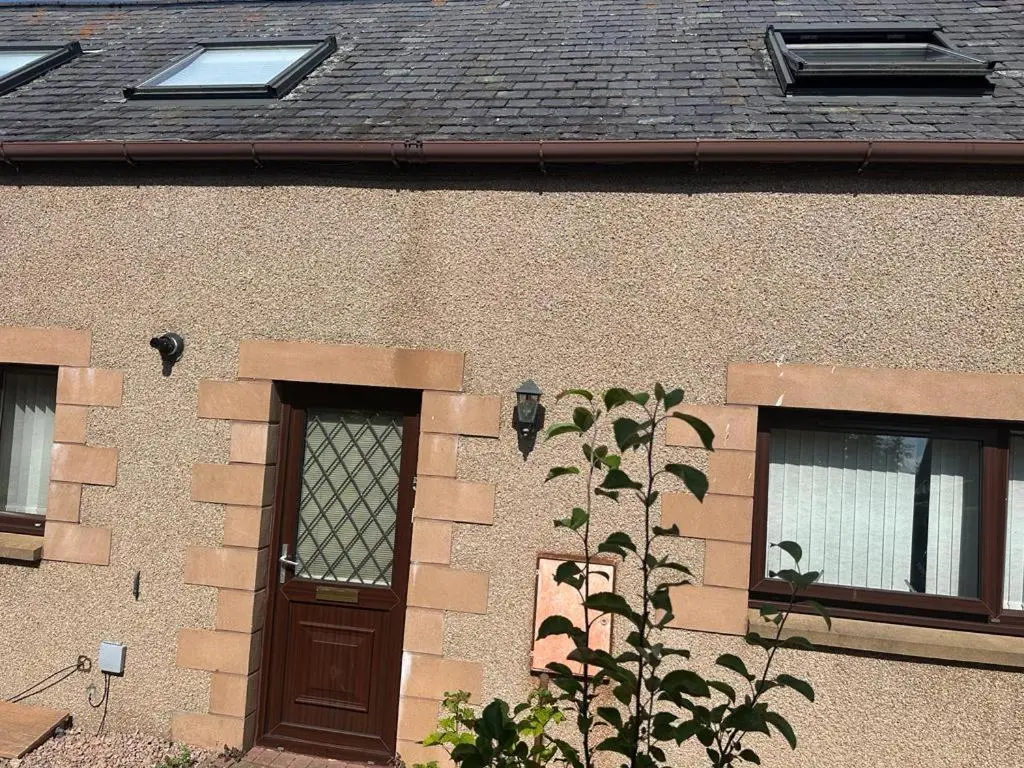 a building with a wooden door and two windows at Buckie Haven 3 Bed Contractors Business Travellers in Buckie