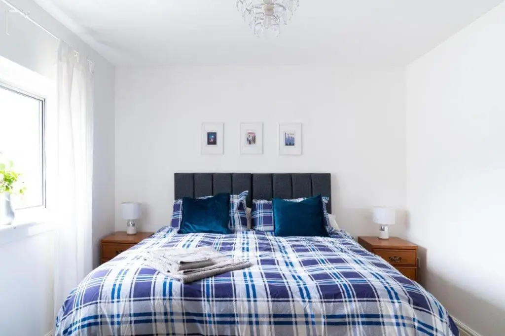 a bedroom with a blue and white bed with blue pillows at Buckie Haven 3 Bed Contractors Business Travellers in Buckie